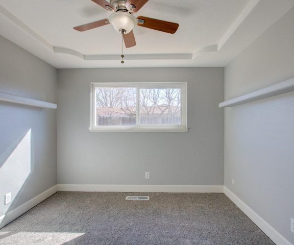 room with brown ceiling fan and gray walls