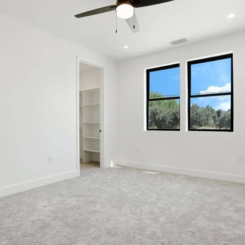 room with ceiling fan and white walls